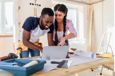 Image of a happy couple reviewing their home renovation blueprints together.